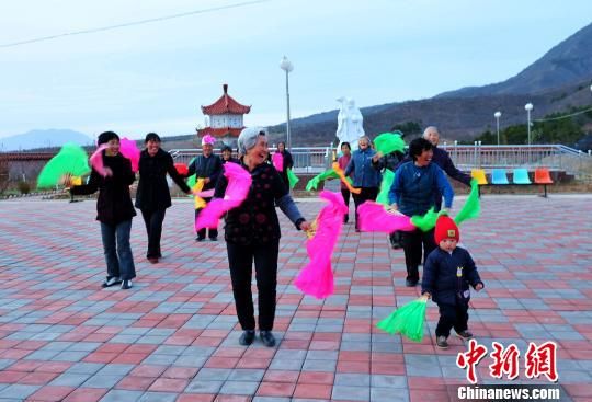 一個(gè)小孩隨著老人們?cè)诠⒃豪锱て鹆搜砀瑁堑美先藗冮_(kāi)懷大笑。張帆攝